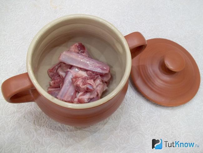 Мясо нарезано и разложено по горшочкам