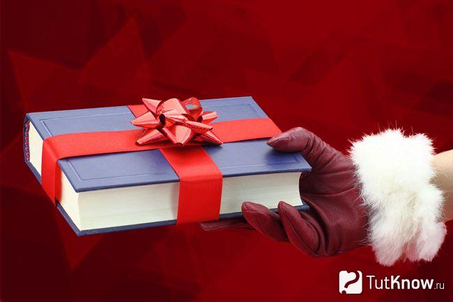 Книга, обёрнутая новогодней подарочной лентой