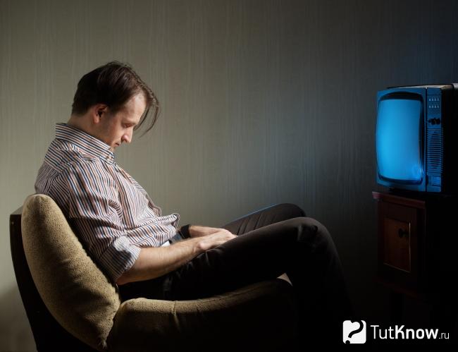 Мужчина дремлет перед телевизором