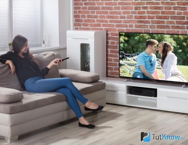 Женщина смотрит сериал по телевизору