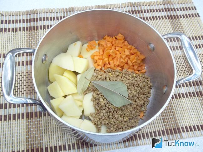 Картофель, морковь и чечевица сложены в кастрюлю