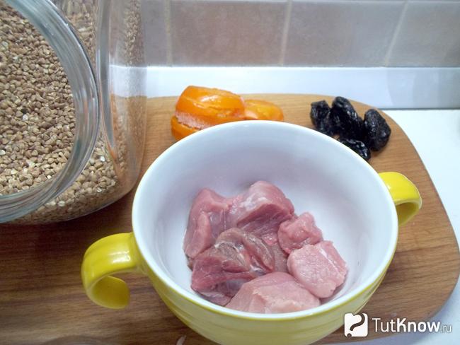 Мясо нарезано кусочками и сложено в горшочки