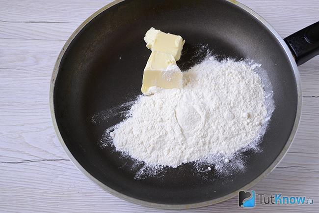 Мука и кусок сливочного масла на сковородке