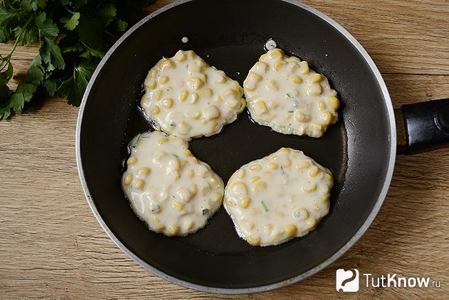 Оладьи с консервированной кукурузой жарятся на сковородке