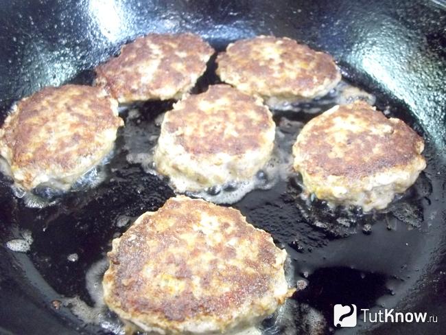 Сборные оладьи из мяса, овощей и рыбной икры жарятся на сковороде