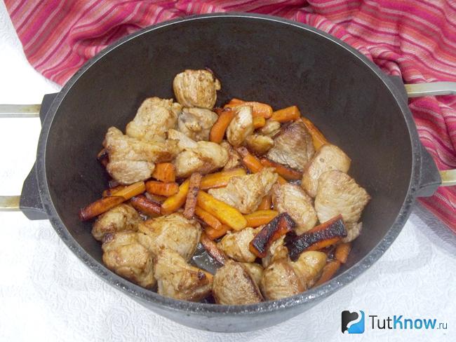 Мясо с морковью жарятся на плите