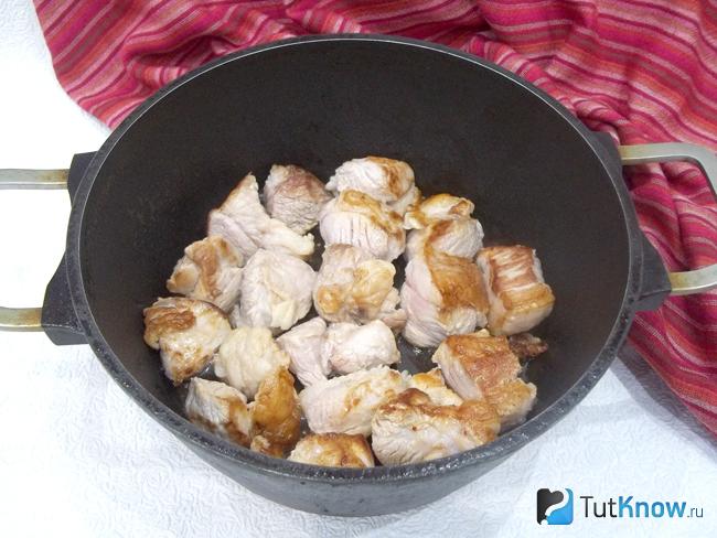 Мясо нарезано и жарится в казане до румяной корочки