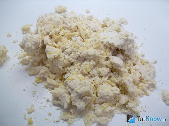 Песочное тесто на маргарине и яйцах выложено на рабочую поверхность