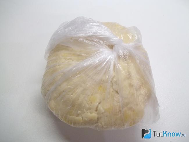 Песочное тесто на маргарине и яйцах обернуто полиэтиленом и отправлено в холодильник