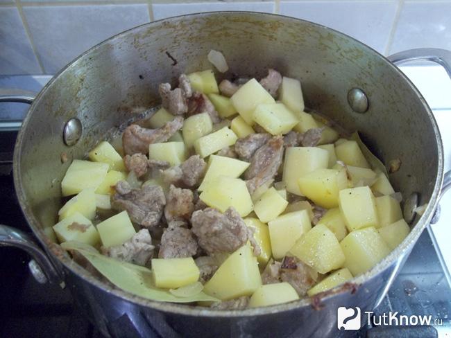 Мясом с луком и картофелем перемешаны и залиты питьевой водой