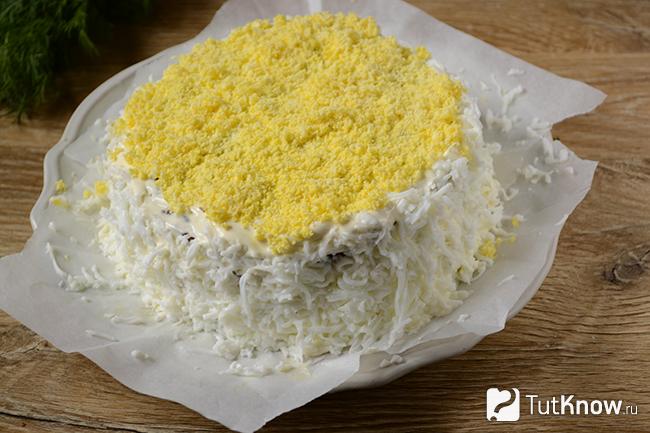 Бока торта украшены измельчённым яичным белком, а вершина - желтком