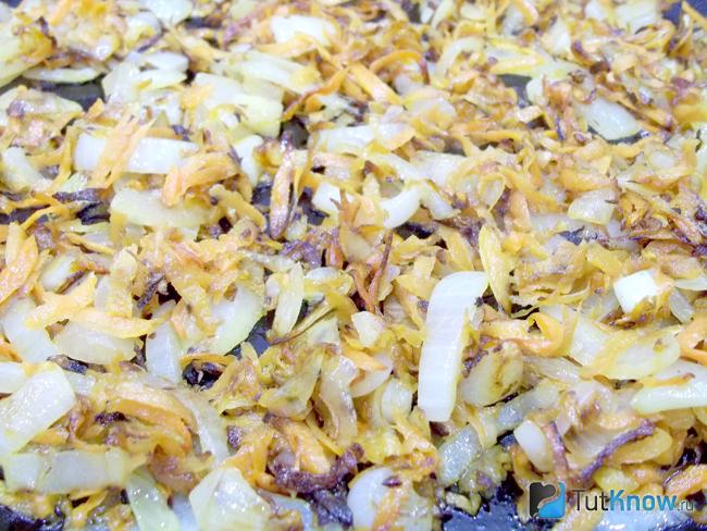 Морковь и репчатый лук нарезаны и жарятся в сковороде в масле