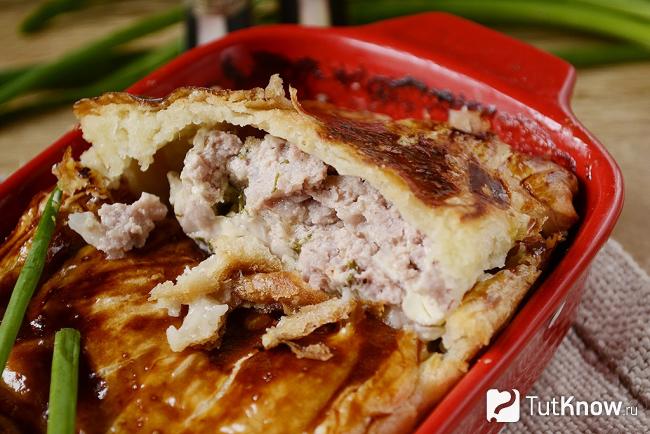 Мясной пирог из слоеного теста с фаршем и творогом крупным планом