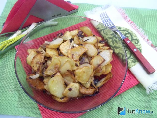 Готовая жареная картошка с луком, чесноком и салом на сковороде