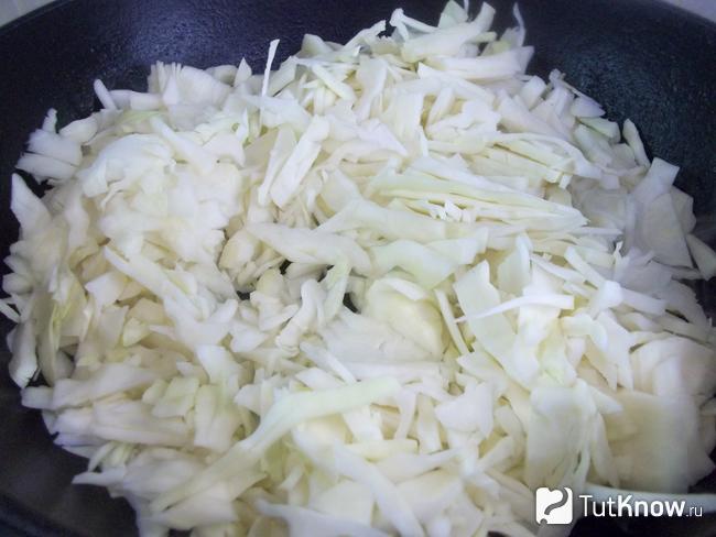 Капуста нашинкована тонкой соломкой и жарится в сковороде