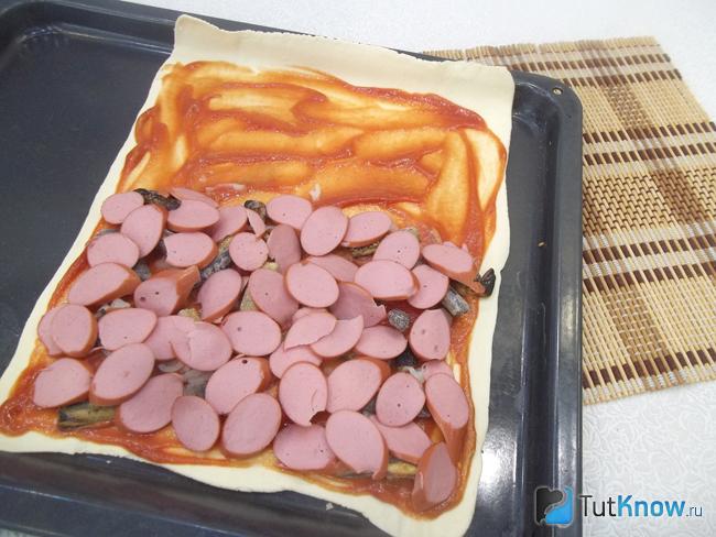 На тесто добавлена нарезанная кольцами колбаса