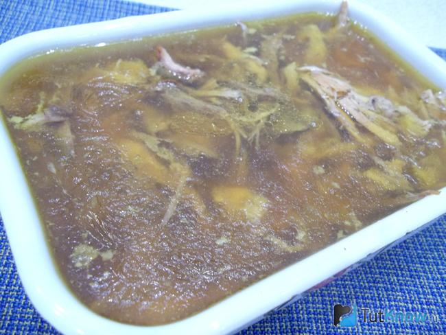Мясо залито бульоном и холодец из курицы отправлен застывать в холодильник