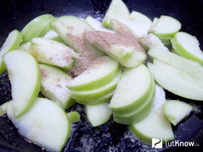 Яблоки нарезанные дольками жарятся в сковороде