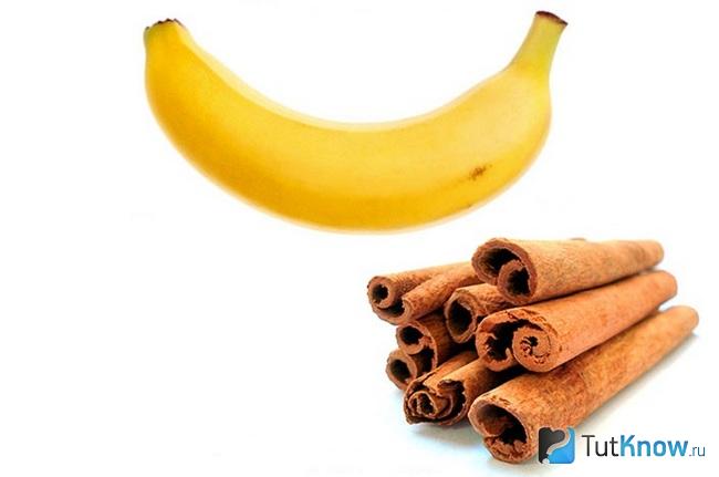 Банан и трубочки корицы на белом фоне