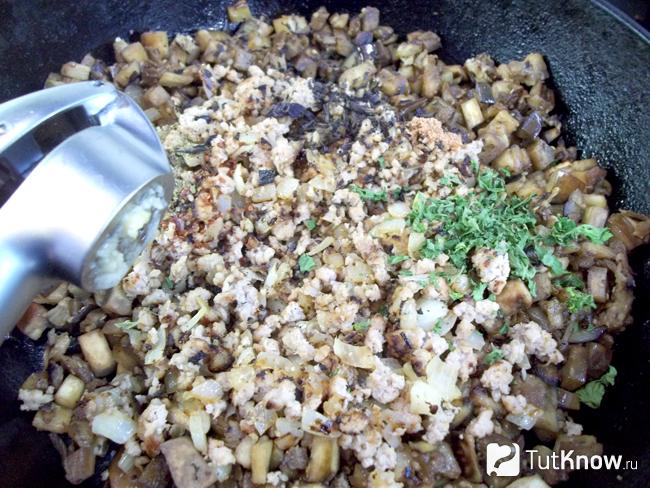Синие жареные с мясом на сковороде приправлены чесноком, солью и пряностями