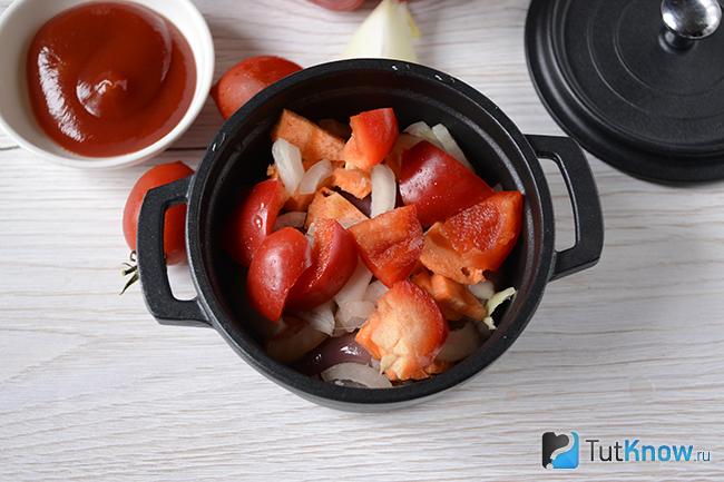 Перец и помидоры выложены поверх лука, моркови и куриных сердечек