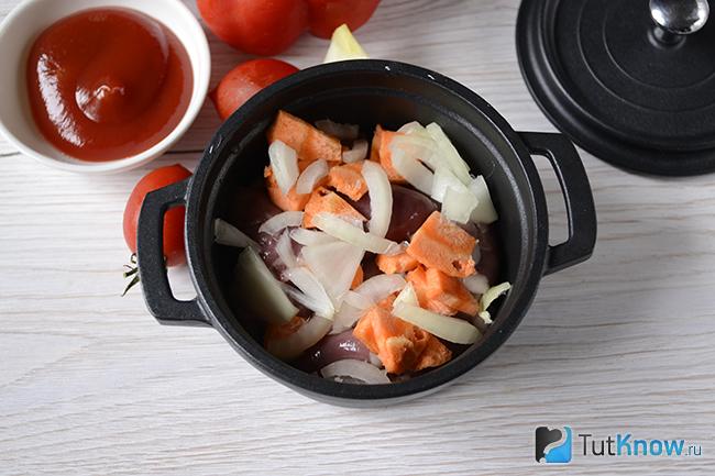 Нарезанные лук и морковь выложены поверх куриных сердечек