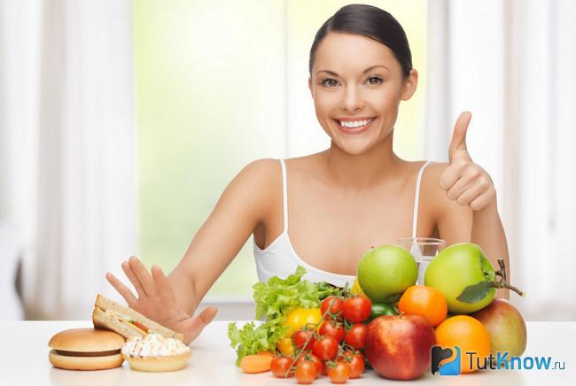 Девушка отодвигает от себя вредные продукты