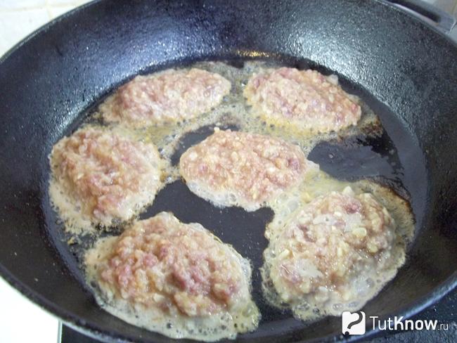 Драники из цукини и мяса утки жарятся на сковороде