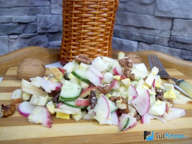 Готовый салат из огурцов, редиски, яблок, яиц и орехов
