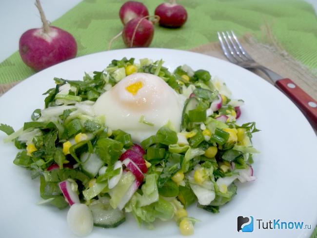 Готовый салат из молодой капусты, кукурузы, черемши и яйца пашот
