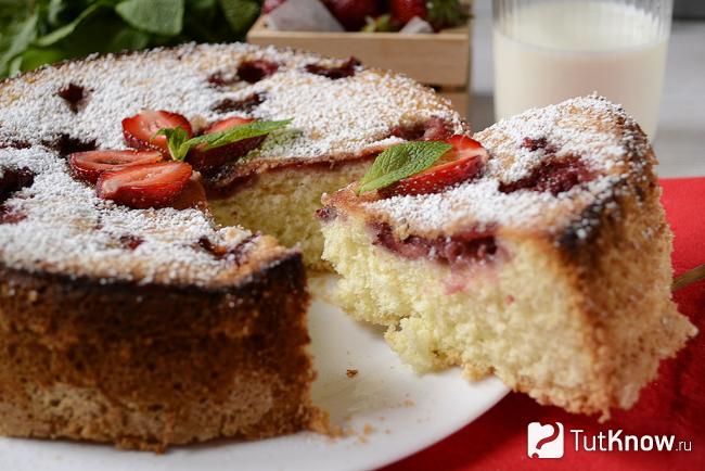 Отрезанный кусочек шарлотки с клубникой