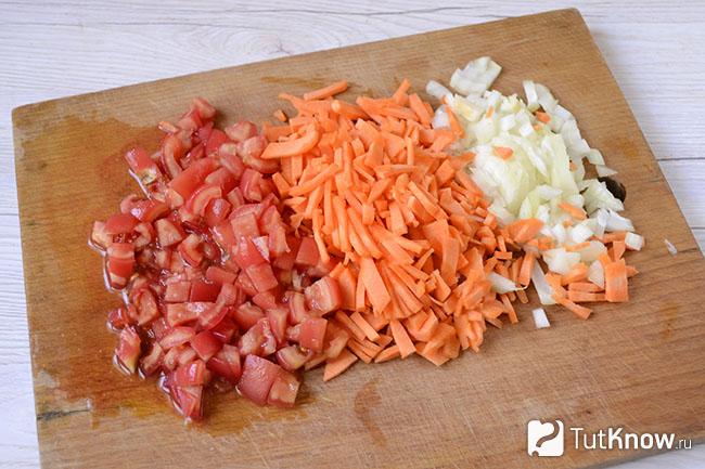 Лук, морковь и помидоры нарезаны на дощечке