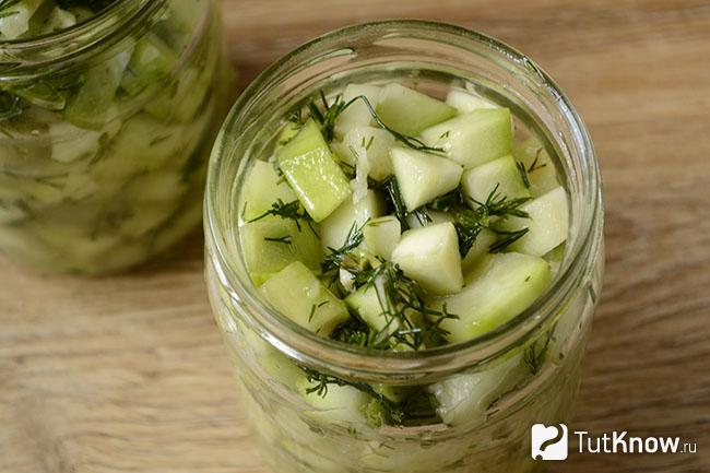 Маринованные кабачки разложены по банкам