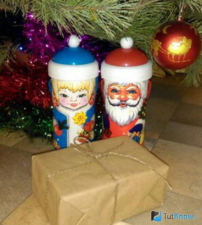 Таинственная коробка возле фигурок Деда Мороза и Снегурочки