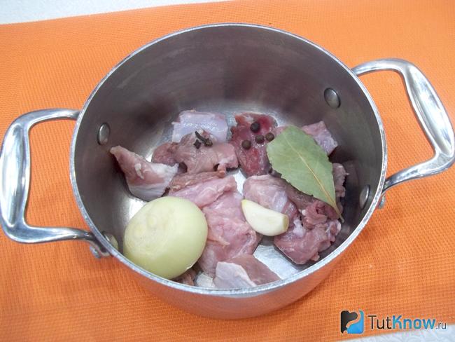 Мясо нарезанное кусочками, очищенная луковица и чеснок сложены в кастрюлю и сварен бульон