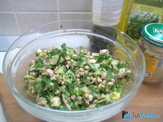 Салат с курицей, огурцом и зеленью заправлен соусом