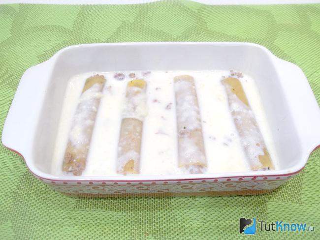 Каннеллони выложены в форму для запекания и залиты молочным соусом