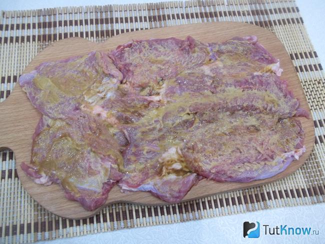 Пласт мяса смазан горчицей и соевым соусом