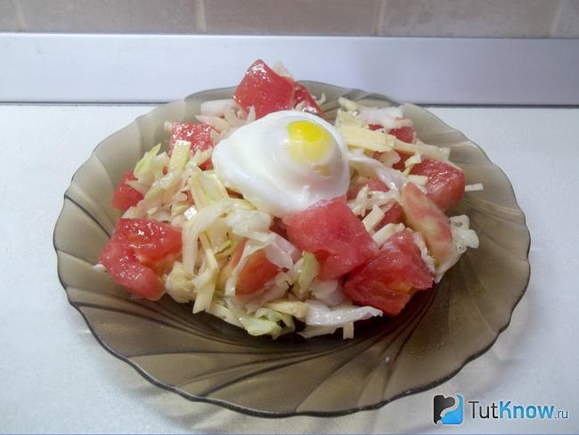 Готовый салат с помидорами, сыром и яйцом-пашот