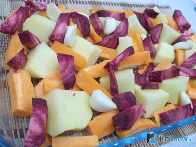 Картофель, морковь и свекла очищены, нарезаны и выложены в форму для запекания