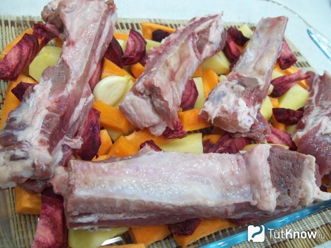 На овощи выложено нарезанное мясо