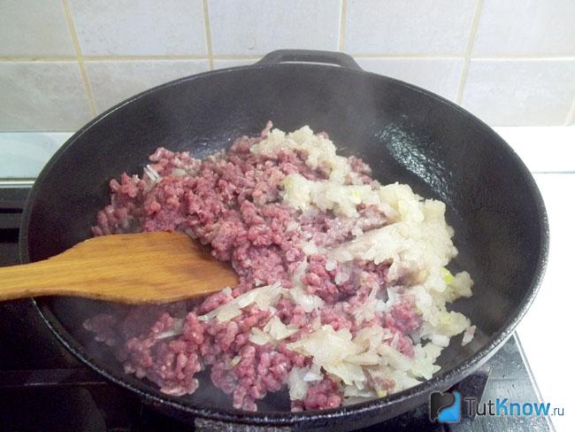 Мясо утки и репчатый лук жарятся в сковороде