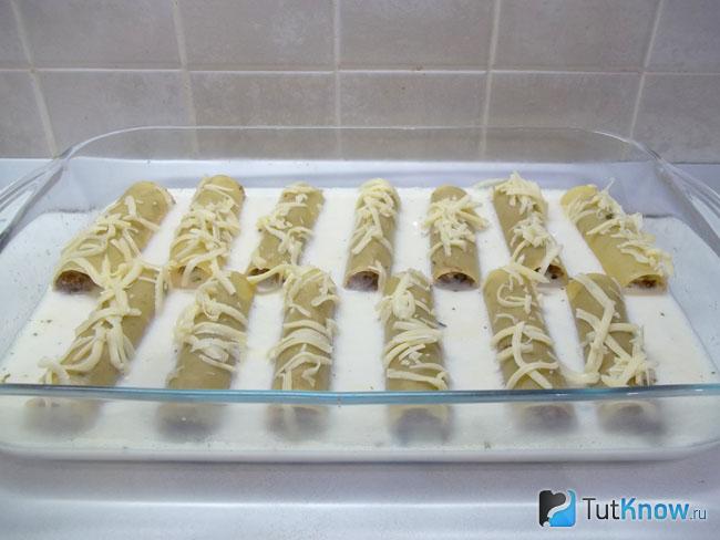 Каннеллони присыпаны сырной стружкой