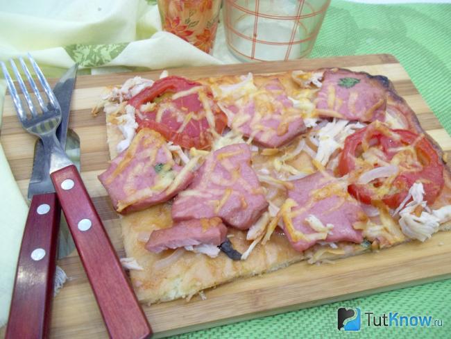 Готовая пицца с курицей, помидорами и кинзой