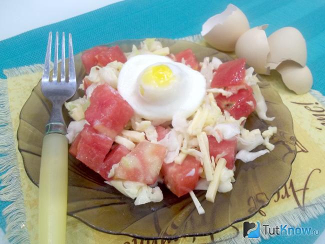 Готовый салат с помидорами, сыром и яйцом-пашот