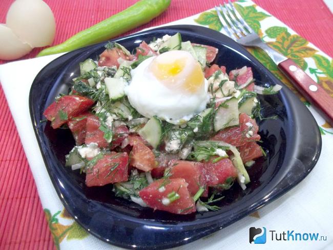 Готовый салат с помидорами, плавленым сыром и яйцом-пашот