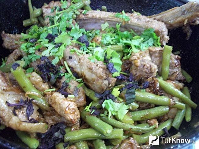 Готовые жареные ребра с луком и спаржей