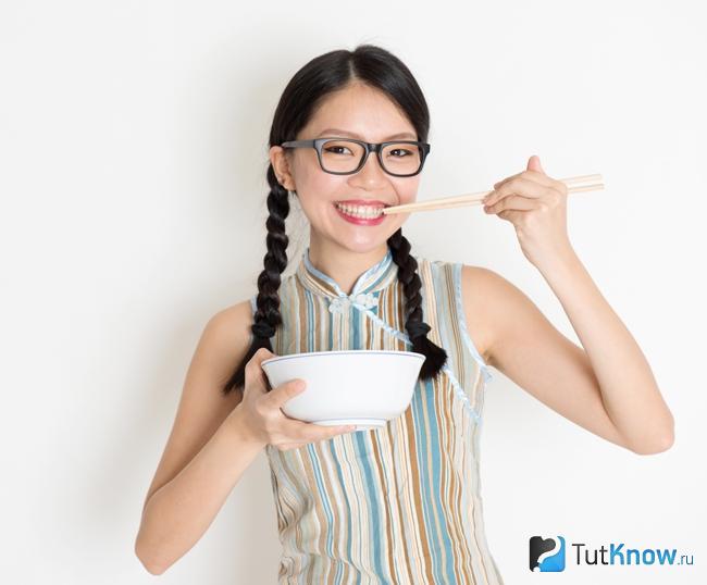 Девушка кушает рисовую лапшу
