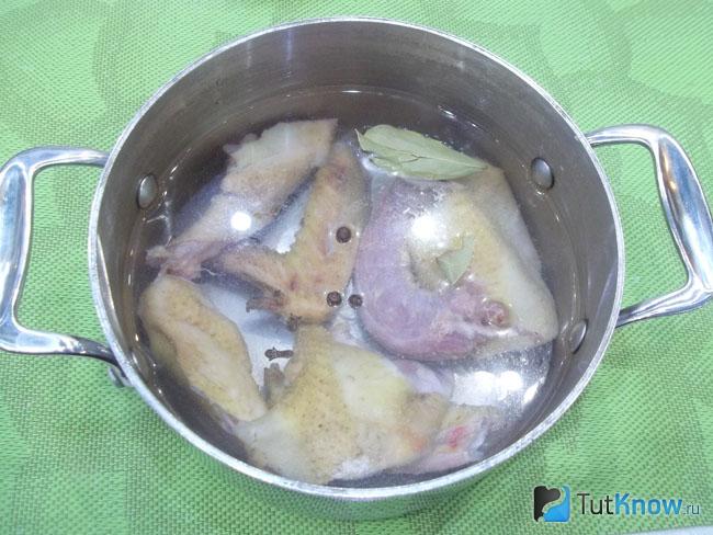 Курица нарезана, отправлена в кастрюлю и залита водой