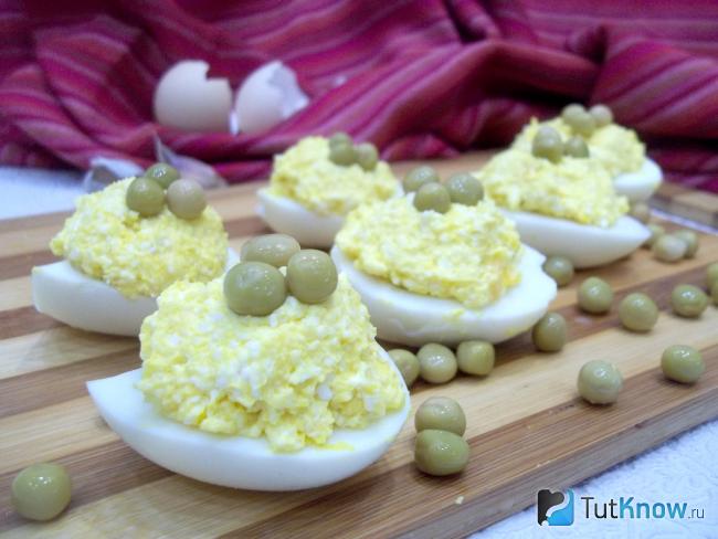 Готовые яйца фаршированные сыром и консервированным горошком